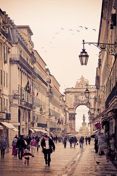 people walking down the street in an old european city