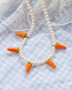 Introducing our Carrot Banquet necklace! Featuring five of our our brand new Carrot charms! Every picnic blanket piece is lovingly designed and handcrafted completely in-house and perfectly finished in our jewellery studio. All of our pearly jewellery features only the highest quality iridescent freshwater pearls.  Every individual glass feature charm takes around half an hour to delicately form by hand in the flame, reaching temperatures of up to 800 degrees celsius, before heading to the kiln Necklace Glass Beads, Jewellery Studio, Jewelry Studio, The Flame, Delicate Jewelry, Necklace Handmade, Glass Jewelry, Pearl Bracelet, Kiln