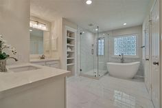 a large bathroom with a tub, sink and shower stall in it's center