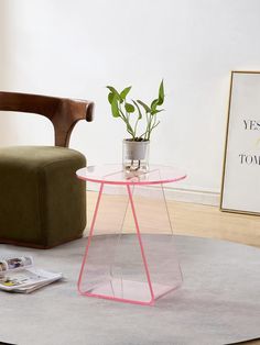 a glass table with a potted plant sitting on top of it next to a chair