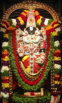 the statue is decorated with flowers and garlands