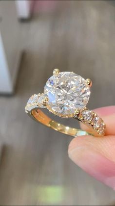 a person holding a ring in their hand with a diamond on the top and side