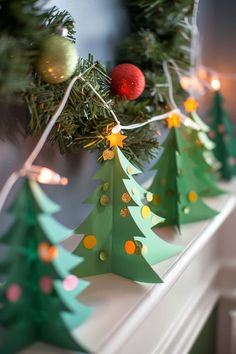 paper christmas trees are lined up on a window sill