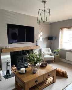 a living room filled with furniture and a flat screen tv mounted on the wall above a fire place