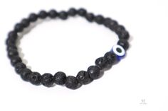 If you want to be protected from the evil eye, look no further. These lava stone gem bracelets are not only stunning but also come with the Blue Eye of Nazar, which is believed to bring protection against evil eye. It is the perfect gift for yourself or someone you love. Lava Stone, (also known as Basalt, or Lava Rock) is an igneous volcanic rock. It has solidified from molten lava, after conditions of intense heat and pressure. Lava Stone is a grounding stone that strengthens one's connection t Spiritual Evil Eye Bracelet With Black Beads For Gift, Black Evil Eye Bracelet Spiritual Style, Casual Lava Stone Jewelry Gift, Casual Evil Eye Beaded Bracelets As Gift, Casual Beaded Evil Eye Bracelet For Gift, Casual Evil Eye Bracelet Perfect For Gifts, Eye Of Nazar, Protection Against Evil Eye, Gem Bracelets