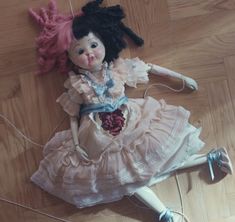 a doll is laying on the floor next to wires