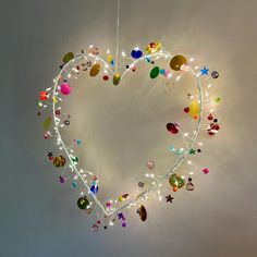 a heart - shaped light hanging from the ceiling with many different colored lights around it