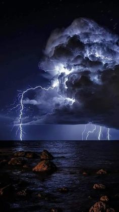 a storm is coming over the ocean with lightning