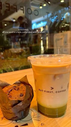 a cup of coffee next to a muffin on a table