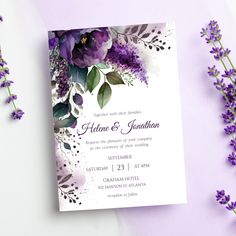 a wedding card with purple flowers and greenery