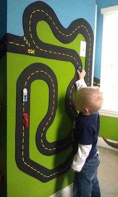 a young boy is playing with a toy race track