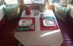 a table with plates and cups on it in front of a window