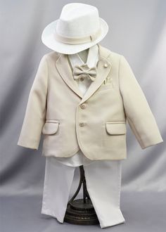 A charming choice for a Baptism outfit and formal wear for a boy. This baptismal outfit features a crisp white button-up shirt paired with tailored pants. A tan blazer, adorned with white enamel buttons, cuff-links, and pins embellished with gold accents, adds a touch of sophistication to this ensemble. Coordinating fedora, bow-tie, and belt are included. Elastic waistband for easy changing. Offered in a 12-18 Month size only. Ideal for wearing after the baptism at church, holidays, weddings, an Classic Beige Semi-formal Sets, Classic Beige Single-breasted Set, Classic White Suits With Button Closure, Elegant White Suits With Button Closure, Classic White Suit With Button Closure, Semi-formal White Sets With Buttons, White Buttoned Semi-formal Sets, White Semi-formal Sets With Buttons, Classic Beige Formal Set