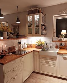 a kitchen filled with lots of white cabinets and counter top space next to a window