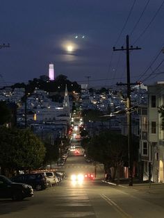 cars are driving down the street at night