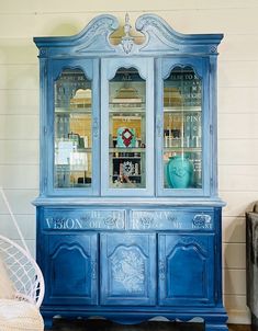 a blue china cabinet with glass doors