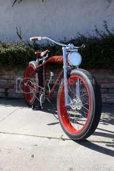 a red and blue bike parked on the sidewalk