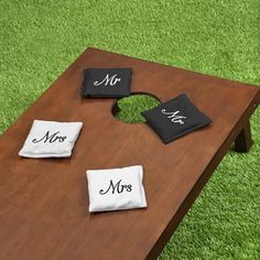 a wooden table topped with two black and white napkins on top of each other