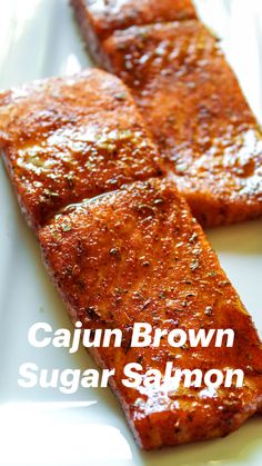 two pieces of brown sugar salmon on a white plate with the words cajun brown sugar salmon