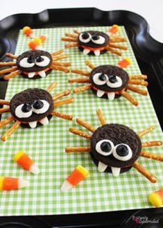 halloween treats made to look like spider cookies on a tray with candy sticks and candies