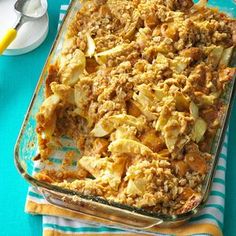 a casserole dish with potatoes and meat in it on a blue table cloth