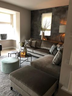 a living room filled with furniture and a fire place next to a large window on top of a carpeted floor