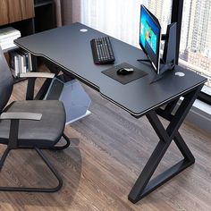 a computer desk with a keyboard, mouse and monitor on it in front of a window