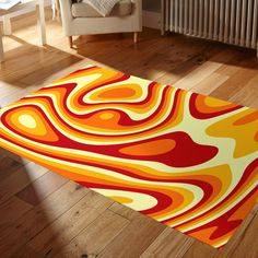 an orange, yellow and red area rug on the floor in front of a white chair