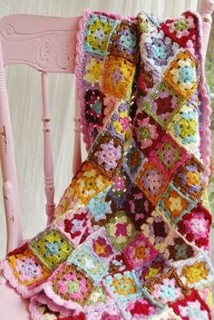 a crocheted blanket sitting on top of a pink chair