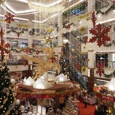 the christmas decorations are hanging from the ceiling in this shopping mall area, and it's decorated with snowflakes