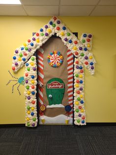 a gingerbread house decorated with candy canes and candies on the front door