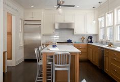 a kitchen with white cabinets and stainless steel appliances is shown in an orange postcard