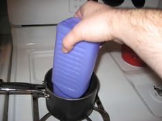 a person is pouring something into a pot on the stove