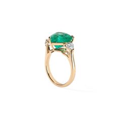 an emerald and diamond ring on a white background