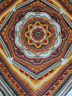 an intricately designed crocheted blanket is shown