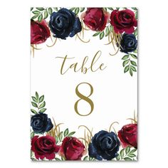 a table number with red and blue roses on it, in gold lettering that says table 8