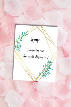 a card with the words love written on it surrounded by pink flowers and greenery