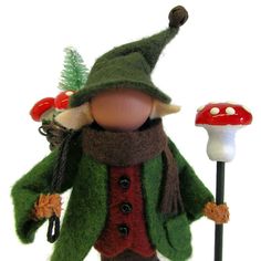 a doll with a green jacket and red shirt holding two mushrooms on it's head