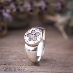 "Wild Flower round signet ring in Sterling silver. This ring is inspired by ancient jewelry style and is made to look a little inaccurate, like ancient roman rings with the craft person signature. The ring is hand sculpted, it was carved in wax and then it was casted in Sterling silver in the lost wax technique. The ring width is (on the front) - 0.3\" inches (8mm) The width on the back side - 0.1\" inches (3mm) Material: Sterling silver 925 * Items ship with a delivery confirmation/Tracking num Symbolic Stamped Signet Ring In Sterling Silver, Symbolic Stamped Sterling Silver Signet Ring, Symbolic Sterling Silver Stamped Signet Ring, Handmade Sterling Silver Open Signet Ring, Handmade Sterling Silver Signet Ring With Open Design, Handmade Sterling Silver Signet Ring With Open Shape, Unique 925 Stamped Signet Promise Ring, Roman Rings, Signet Ring Vintage