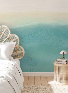 a bedroom scene with focus on the bed and wallpaper that looks like an ocean wave