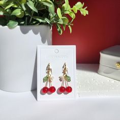 Indulge in the sweet charm of these delightful cherry drop dangle earrings! The vibrant red hue captures the essence of ripe cherries, making these earrings a true delight for the senses. These earrings will sway gracefully with every movement, drawing admiring glances wherever you go.  🍒Material: The earrings are made with red or wine glass cherries, acrylic flowers, acrylic leaves and the 14K gold-plated(hypoallergenic) earring findings. Handmade in Maryland! 🌺 Size: The huggie style is about 1.2cm x 3cm. The hook style is about 1.2cm x 3.5cm. 🎀Handmade: Each item is made to order, which gives our pieces a unique meaning that is specific and special to you. Therefore, there are no two items exactly alike. This product contains small parts. Use caution when giving to young children les Red Cherry Print Jewelry For Gifts, Elegant Cherry Drop Earrings, Cherry Colored Earrings Gift, Cherry Colored Earrings For Valentine's Day Gift, Cherry Earrings For Valentine's Day Gift, Cherry Color Earrings For Valentine's Day Gift, Trendy Cherry Dangle Earrings, Trendy Red Flower Earrings For Gifts, Cherry Colored Drop Earrings With Ear Wire