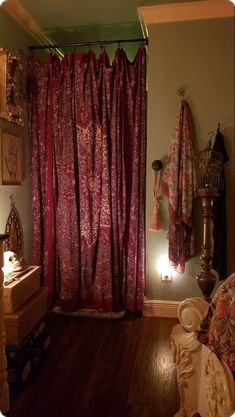 there is a red shower curtain in this bathroom with wood flooring and wooden floors