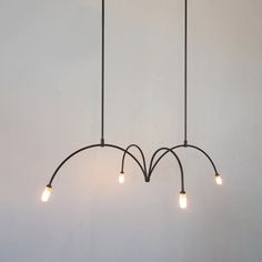 three lights are hanging from the ceiling in a room with white walls and flooring