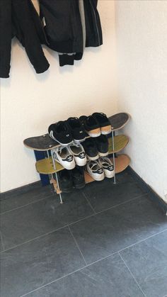 there are many pairs of shoes on top of the skateboard rack in this room