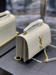 two white purses sitting on top of a table