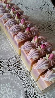 several pieces of pink and white chocolate with flowers on them sitting on a lace doily