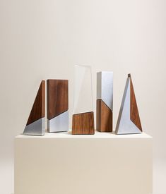 five pieces of wood and metal on a white surface