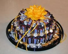 a chocolate cake covered in candy and wrapped in yellow ribbon