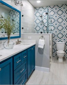 a bathroom with blue cabinets and white fixtures