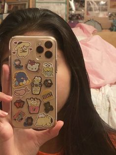 a woman is holding up her phone case with stickers on it